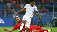 Gelandang Timnas Swiss, Valon Behrami (bawah) mencoba menahan bola dari kaki pemain tengah Inggris, Raheem Sterling, saat berlaga di kualifikasi Euro 2016 di Stadion St Jakob-Park, Basel , (9/9/2014). (REUTERS/Ruben Sprich)