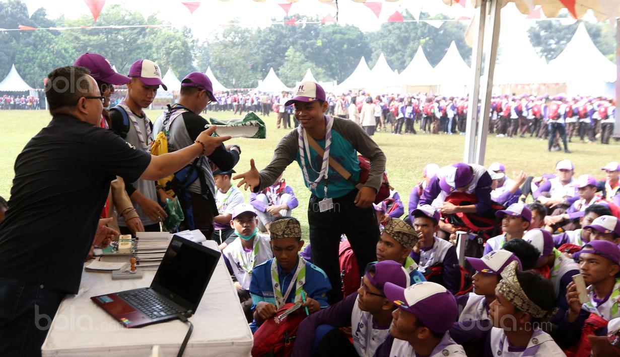 Pemred Bola.com, Darojatun memberikan hadiah kepada peserta Raimuna Nasional XI yang bertanya di Bumi Perkemahan Cibubur, Selasa (15/8/2017). Kegiatan ini sebagai bentuk dari pembelajaran jurnalistik olahraga. (Bola.com/Nicklas Hanoatubun)