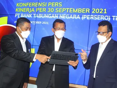Direktur Utama PT Bank Tabungan Negara (Persero) Tbk. Haru Koesmahargyo (tengah) didampingi Jajaran Direksi Bank BTN Hirwandi Gafar (kiri) dan Nofry Rony Poetra (kanan) berbincang melihat laporan keuangan perseroan per 30 September 2021 di Jakarta, Kamis (21/10/2021). (Liputan6.com/HO/BTN)