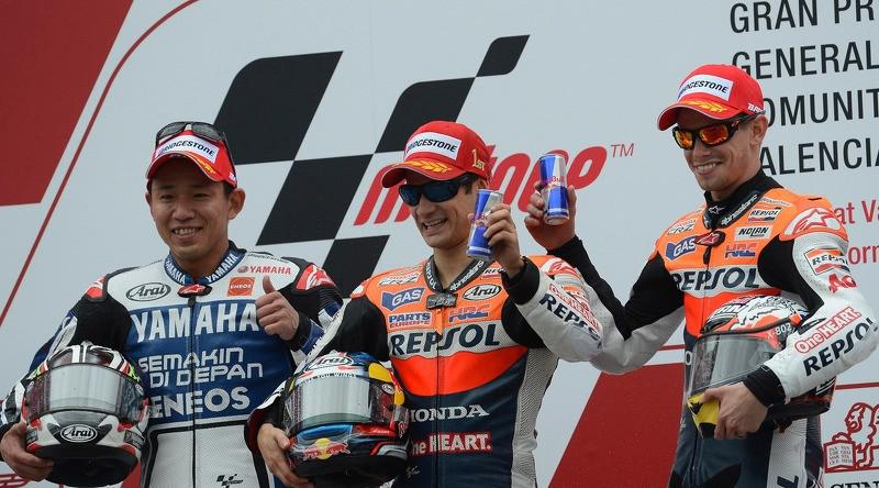Pebalap Yamaha, Katsuyuki Nakasuga (kiri), berpose dengan dua rider Honda, Dani Pedrosa (tengah) dan Casey Stoner, di podium MotoGP Valencia 2002. (Motorsport)
