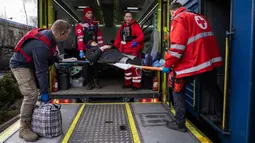 Relawan Palang Merah membawa seorang wanita dengan tandu ke kereta medis Medecins Sans Frontieres (MSF) atau Doctors Without Border saat mengevakuasi pasien dari dekat garis depan pertempuran ke daerah yang lebih aman di stasiun kereta di Pokrovsk, Ukraina, 7 Maret 2023. MSF merupakan kereta medis khusus yang dapat membawa pasien dari bagian timur Ukraina ke rumah sakit di bagian barat. (AP Photo/Evgeniy Maloletka)