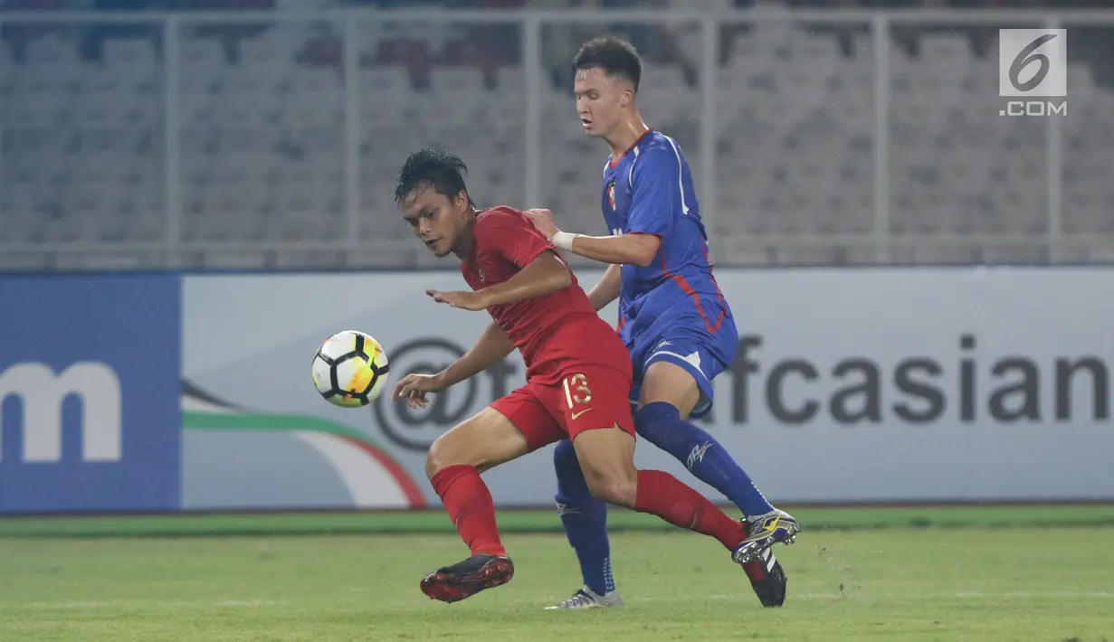 Pemain Timnas Indonesia U-19, Rachmat Irianto (kiri) berebut bola dengan pemain Chinnese Taipei saat laga penyisihan Grup A Piala AFC U-19 2018 di Stadion GBK, Jakarta, Kamis (18/10). Babak pertama berakhir imbang 0-0. (Liputan6.com/Helmi Fithriansyah)