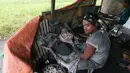 Pekerja memasukkan bubuk mesiu ke dalam sebuah tabung kecil saat membuat kembang api di sebuah gubuk, provinsi Bulacan, utara Manila, Rabu (27/12). Warga Filipina menyiapkan kembang api untuk menyambut tahun baru 2018. (AP/Bullit Marquez)
