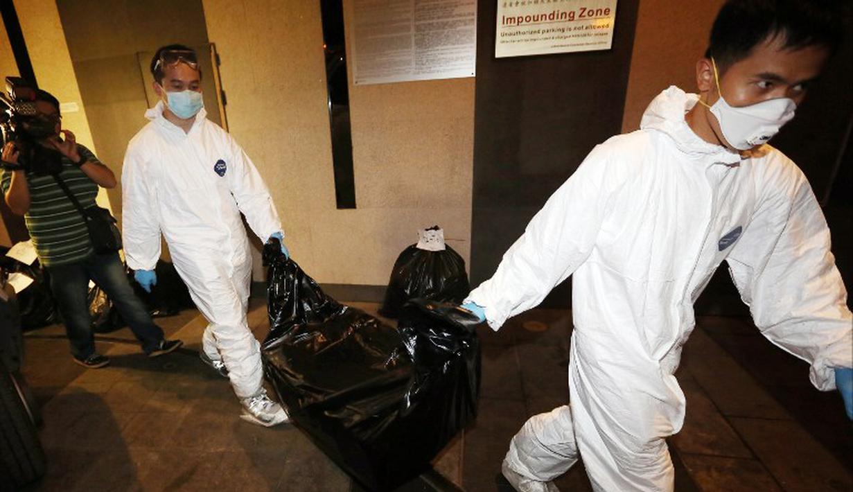 Petugas mengangkat jenazah korban pembunuhan sadis di Hong Kong, salah satunya WNI, Sumarti Ningsih, Sabtu (1/11/2014). (AFP PHOTO/South China Morning Post)