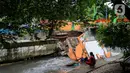 Warga melihat pos pantau Pintu Air yang rubuh di wilayah Palmerah, Jakarta, Selasa (6/2/2024). (Liputan6.com/Herman Zakharia)