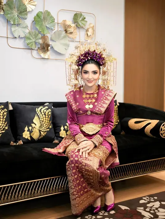 Kali ini, ia tampil anggun mengenakan busana adat Komering berwarna ungu emas yang mewah [@ashany_ash]