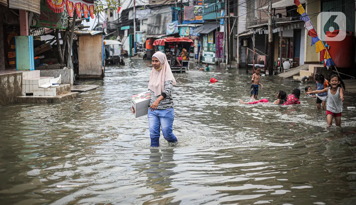 Warga beraktivitas saat banjir rob di Muara Angke, Jakarta, Jumat (25/11/2022). Badan Penanggulangan Bencana Daerah (BPBD) DKI Jakarta mengimbau agar warga di pesisir Jakarta mengantisipasi banjir pesisir atau rob selama 22-28 November 2022. (Liputan6.com/Faizal Fanani)