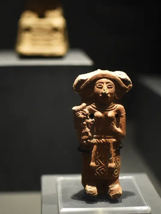 Patung Mesoamerika dari tradisi makam poros yang berasal dari 300 AC hingga 600 DC dipamerkan di Pusat Kebudayaan Universitas Tlatelolco di Mexico City (8/12/2021). (AFP/Rodrigo Arangua)