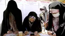 Para pemilih mengisi surat suara selama pemilihan presiden di sebuah tempat pemungutan suara di Teheran, Iran, Jumat (18/6/2021). Warga Iran mulai memberikan suaranya dalam pemilihan presiden. (AP Photo/Ebrahim Noroozi)
