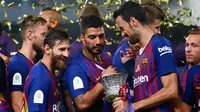 Pemain Barcelona melihat Piala Super Spanyol usai pertandingan melawan Sevilla di Tangier, Maroko, (13/8). Barcelona meraih gelar ke-13 di Piala Super Spanyol terbanyak ketimbang tim lain. (AP Photo/Mosa'ab Elshamy)