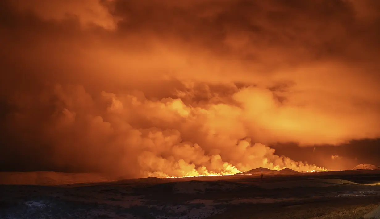 Langit malam diterangi cahaya akibat letusan gunung berapi di Grindavik di Semenanjung Reykjanes Islandia, Senin (18/12/2023). (AP Photo/Marco Di Marco)