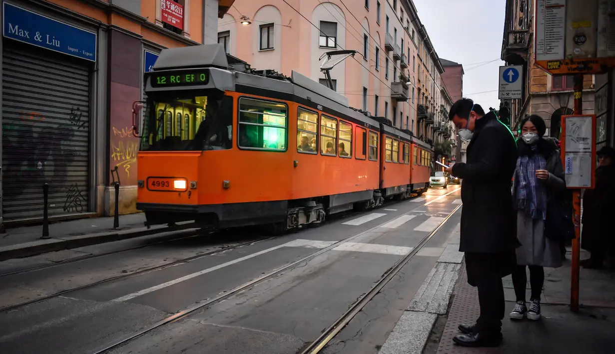 Aktivitas warga di sebuah jalan di pusat Kota Milan, Italia, Selasa (25/2/2020). Warga banyak mengurangi aktivitas di luar rumah terkait virus corona atau COVID-19 di Italia. (Claudio Furlan/LaPresse via AP)