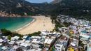 Foto udara memperlihatkan Desa Shek O dan pantainya yang tertutup di Hong Kong, Kamis (17/3/2022). Pemerintah Hong Kong mengatakan akan menutup pantai umum untuk mengekang penyebaran virus corona COVID-19. (DALE DE LA REY/AFP)
