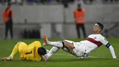 Pemain Portugal, Cristiano Ronaldo (kanan) berebut bola dengan kiper Slovakia, Martin Dubravka saat laga grup G Kualifikasi Euro 2024 di National Football Stadium in Bratislava, Slovakia, Sabtu (9/9/2023) dini hari WIB. Pertandingan tersebut diwarnai dengan insiden tekel horor Ronaldo ke kepala kiper Slovakia. (AP Photo/Radovan Stoklasa)