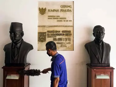 Petugas membersihkan patung di Museum Sumpah Pemuda, Jakarta, Rabu (27/10/2021). Jelang peringatan Hari Sumpah Pemuda pada tanggal 28 Oktober, pengelola Museum Sumpah Pemuda mulai membenahi museum. (Liputan6.com/Faizal Fanani)