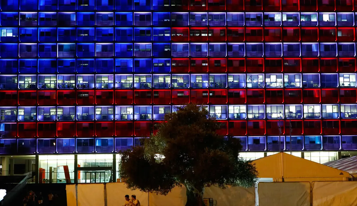 Pemendangan balai kota Tel Aviv yang dihiasi warna bendera AS untuk menghormati korban penembakan brutal di Las Vegas di Rabin Square, Tel Aviv (2/10). Akibat kejadian ini sekitar 59 orang tewas dan 500 lainya terluka. (AFP Photo/Jack Guez)