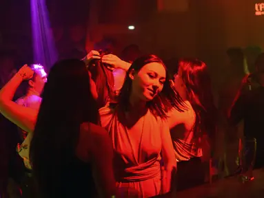 Sejumlah wanita menari di kelub malam di Saint-Jean-de-Monts, Prancis barat, Sabtu (10/7/2021). Penggemar kehidupan malam di Prancis kini kembali bisa berpesta di kelab favorit mereka. (AFP/Sebastien Salom-Gomis)