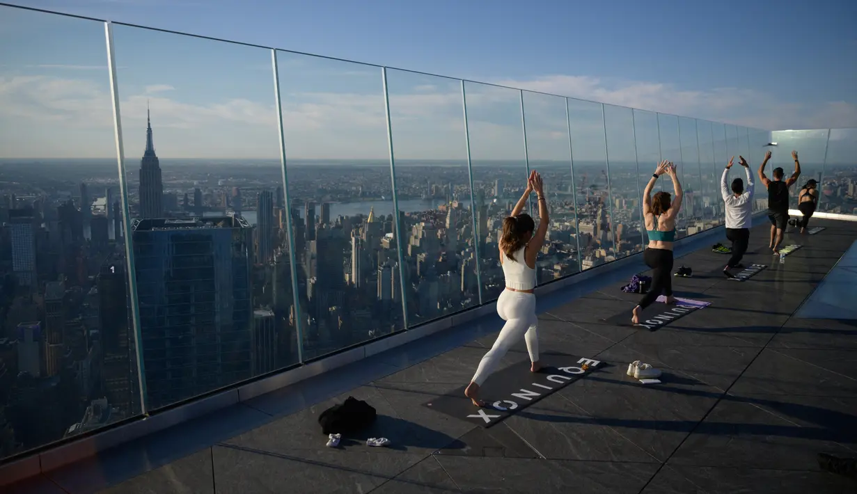 Praktisi yoga menghadiri kelas di Edge Observation Deck, Manhattan, New York, Amerika Serikat, Kamis (17/6/2021). Edge Observation Deck memiliki ketinggian 1.131 kaki (345 meter). (Ed JONES/AFP)