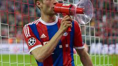 Sebelum naik pagar, Mueller mencoba mikrofon yang diberikan suporter (GUENTER SCHIFFMANN / AFP)