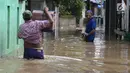 Warga melintasi banjir di kampung Arus Cawang, Jakarta Timur, Jumat (26/4). Ketinggan banjir kurang lebih satu meter terjadi akibat luapan kali Ciliwung dan intensitas curah hujan di kawasan Bogor Jawa Barat sangat tinggi sehingga aktivitas warga terhambat. (merdeka.com/Imam Buhori)