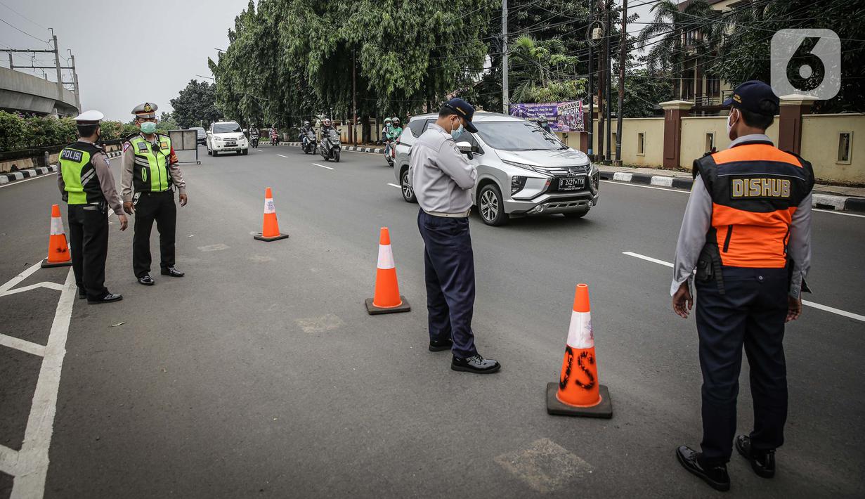 Petugas mengawasi kendaraan yang melintasi pos cekpoin penyekataan arus mudik di kawasan Pasar Jumat, Kamis (6/5/2021). Penyekatan dan cek poin dilakukan saat penerapan larangan mudik Lebaran 2021 sebagai upaya pencegahan penularan COVID-19. (Liputan6.com/Faizal Fanani)