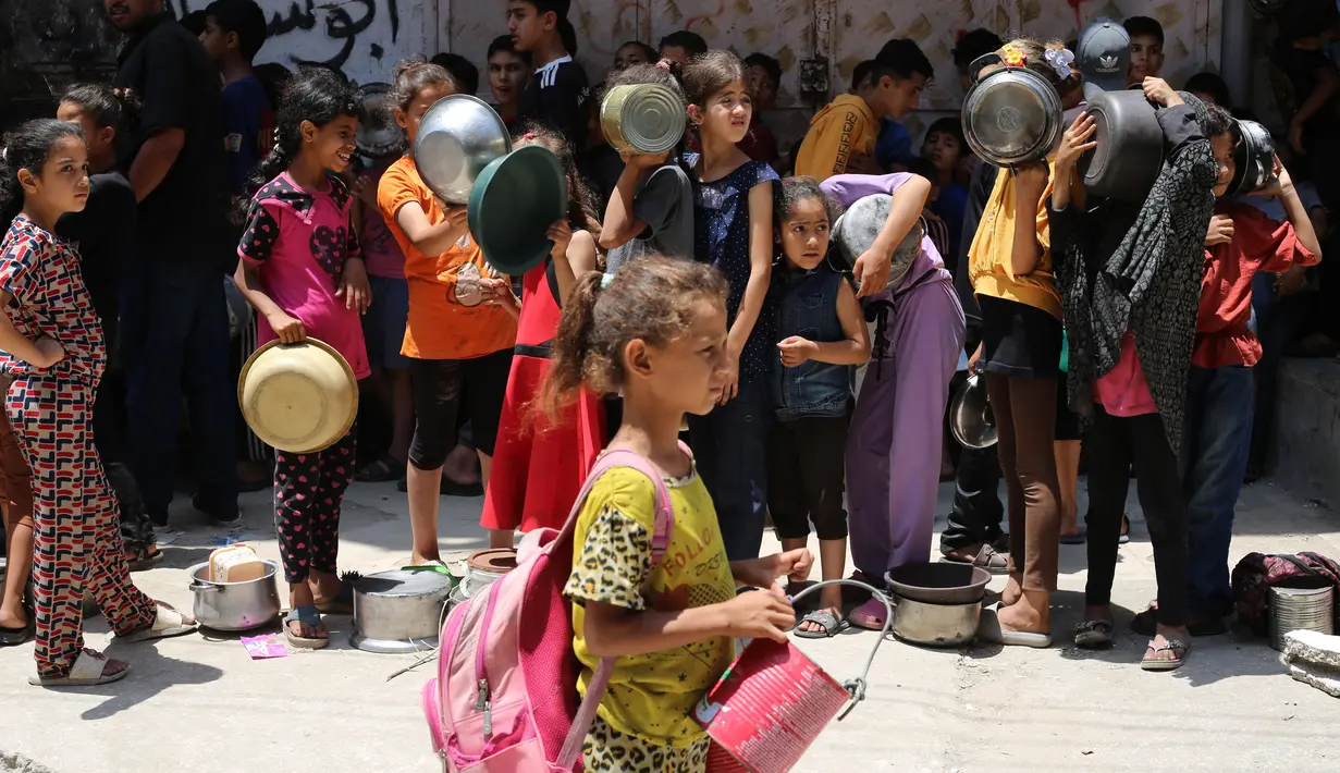Anak-anak Palestina menunggu di titik distribusi makanan di Nuseirat, Jalur Gaza bagian Tengah, pada 23 Juni 2025. (Eyad BABA/AFP)