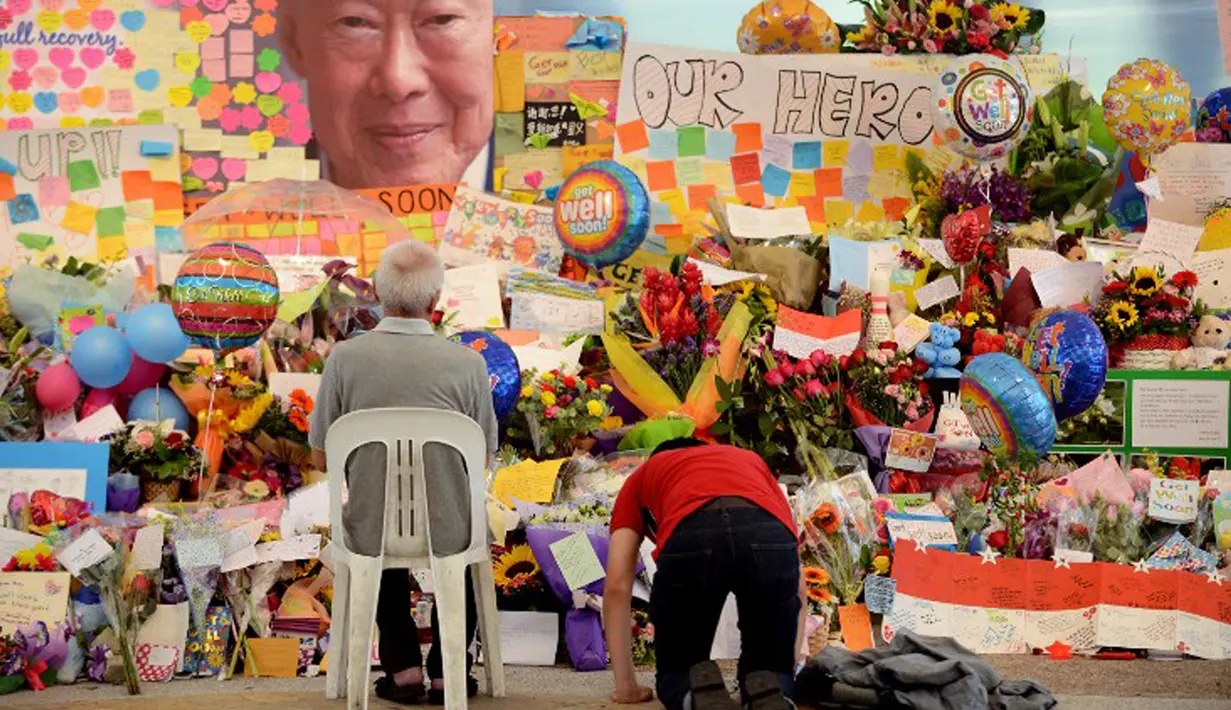 Warga memberikan penghormatan di depan karangan bunga dan kartu ucapan duka meninggalnya Mantan PM Singapura, Lee Kuan Yew di Singapore General Hospital, Senin (23/3/2015). (AFP PHOTO/Mohd Fyrol)