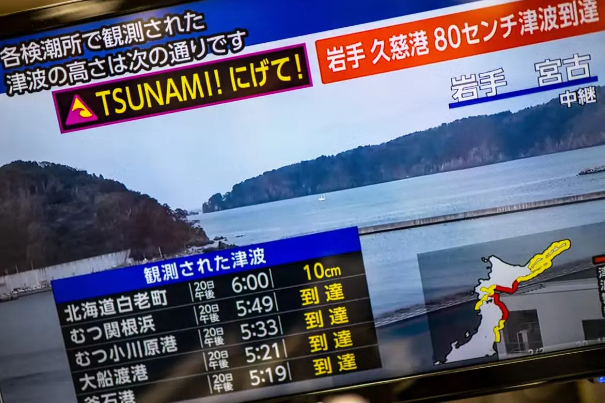 Foto ini menunjukkan pesan peringatan di layar dari siaran langsung NHK dengan peringatan tsunami setelah gempa bumi magnitudo 7,7 melanda Jepang pada 20 April 2026. (Dok. AFP/Philip Fong)