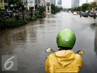 Pengendara motor berhenti sebelum melintasi genangan air di kawasan Kelapa Gading, Jakarta, Jumat (26/2/2016). Hujan deras yang mengguyur Ibukota membuat beberapa ruas jalanan tersendat. (Liputan6.com/Faizal Fanani)