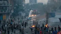 Pengunjuk rasa antipemerintah membakar sejumlah benda dan memblokir jalan saat menggelar protes di Baghdad, Irak, Rabu (2/10/2019). Aksi protes di seluruh Irak telah menewaskan sembilan orang dalam 24 jam. (AP Photo/Hadi Mizban)