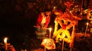 Seorang wanita menyalakan lilin di sebelah makam orang yang dicintainya pada perayaan Hari Kematian di pemakaman Arocutin, Michoacan, Meksiko, 1 November 2021. Pada Hari Kematian, kerabat menghabiskan malam di samping makam orang yang mereka cintai. (AP Photo/Eduardo Verdugo)