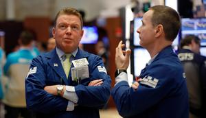 Spesialis Michael Mara (kiri) dan Stephen Naughton berunding saat bekerja di New York Stock Exchange, AS, Rabu (11/3/2020). Bursa saham Wall Street anjlok pada akhir perdagangan Rabu (11/3/2020) sore waktu setempat setelah WHO menyebut virus corona COVID-19 sebagai pandemi. (AP Photo/Richard Drew)
