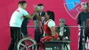 Atlet Para Powerlifting Indonesia, Siti Mahmudah toss bersama pelatih usai mengangkat beban di kelas Womens Up 79kg Asian Para Games 2018 di Jakarta, Rabu (10/10). Siti Mahmudah meraih perak dengan total angkatan 120 kg. (Liputan6.com/Helmi Fithriansyah)