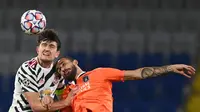 Harry Maguire berduel dengan pemain Istanbul Basaksehir di matchday 3 Liga Champions 2020/2021. Manchester United takluk 1-2. (OZAN KOSE / AFP)