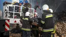 Petugas pemadam kebakaran membawa mayat seorang pria yang tewas setelah sebuah pesawat tak berawak menghantam gedung-gedung di Kyiv, Ukraina, Senin (17/10/2022). Pesawat tak berawak menghantam sejumlah gedung ibu kota Ukraina pada Senin pagi ledakan tesebut menggema di seluruh Kyiv dan menimbulkan kepanikan sehingga orang-orang berlarian ke lokasi yang aman. (AP Photo/Roman Hrytsyna)