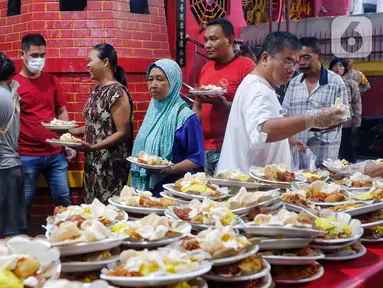 Panitia membagikan hidangan berbuka puasa di Vihara Dharma Bhakti, Petak Sembilan, Jakarta, Selasa (28/3/2023). (Liputan6.com/Angga Yuniar)