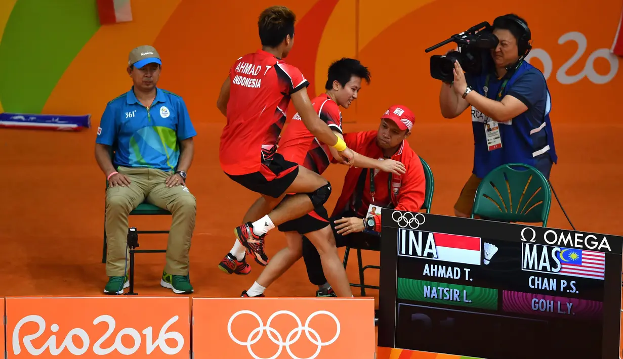 Tontowi Ahmad dan Liliyana Natsir merayakan kemenangan bersama pelatihnya Richard Mainaky usai meraih medali emas Olimpiade Rio 2016 saat mengalahkan Peng Soon Chan dan Liu Ying Goh dari Malaysia. (AFP/Ben Stansall)