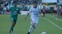 Bek Bali United, Dias Angga Putra (putih), berusaha mengamankan bola dari kejaran pemain PSS, Sidik Saimima, di Stadion Maguwoharjo, Rabu (6/11/2019). (Bola.com/Vincentius Atmaja)