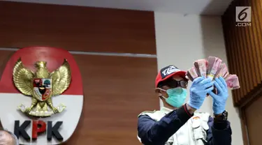 Petugas KPK menunjukkan barang bukti hasil OTT terhadap Bupati Pakpak Bharat Sumatera Utara, Remigo Yolanda Berutu di Gedung KPK, Jakarta, Minggu (18/11). KPK menetapkan tiga tersangka dan menyita uang Rp 150 juta. (Liputan6.com/Helmi Fithriansyah)