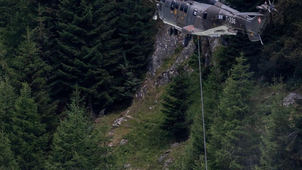Helikopter Super Puma Angkatan Udara Swiss saat mengambil air dari Stausee Gibidum untuk memadamkan api yang membakar lahan hutan di wilayah pegunungan Bitsch dekat Brig, Swiss, Selasa (18/7/2023).