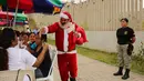 Jose Luis Pereira tahanan asal Extremadura, Spanyol menggenakan kostum santa saat menyapa  narapidana lainnya untuk menyemarakkan perayaan Hari Natal di Penjara Ancon, Callao, Peru, Kamis (22/12). (REUTERS/Mariana Bazo)
