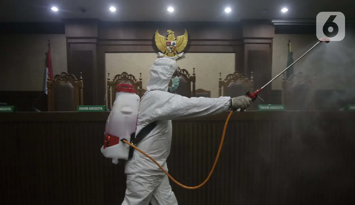 Petugas Palang Merah Indonesia saat melakukan penyemprotan cairan disinfektan di salah satu ruang sidang Pengadilan Negeri Jakarta Pusat, Rabu (18/3/2020). Penyemprotan cairan disinfektan untuk mencegah penyebaran virus corona COVID-19. (Liputan6.com/Helmi Fithriansyah)