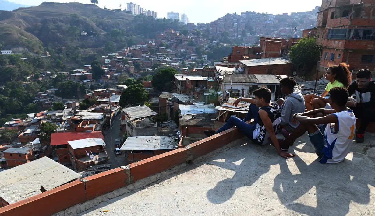 Sejumlah musisi menikmati pemandangan di permukiman kumuh Petare di Caracas pada 19 Mei 2019. Petare yang merupakan kawasan kumuh terbesar di Venezuela menjadi rumah bagi lebih dari 500.000 jiwa. (Photo by MARVIN RECINOS / AFP)