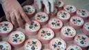 Gambar yang diambil pada 27 Oktober 2021 ini menunjukkan seorang pekerja sedang menyortir kaleng sampel makanan kucing yang bahan dasarnya terbuat dari kepompong ulat sutra di sebuah pabrik makanan hewan di Miaoli, Taiwan. (Sam Yeh/AFP)