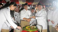 Ketua Dewan Pembina Partai Gerindra, Prabowo Subianto memberikan potongan tumpeng ke Gubernur DKI Jakarta, Anies Baswedan dalam Hari Ulang Tahun ke-10 Tahun yang digelar di kantor DPP Partai Gerindra, Jakarta, Sabtu (10/2). (Liputan6.com/Herman Zakharia)