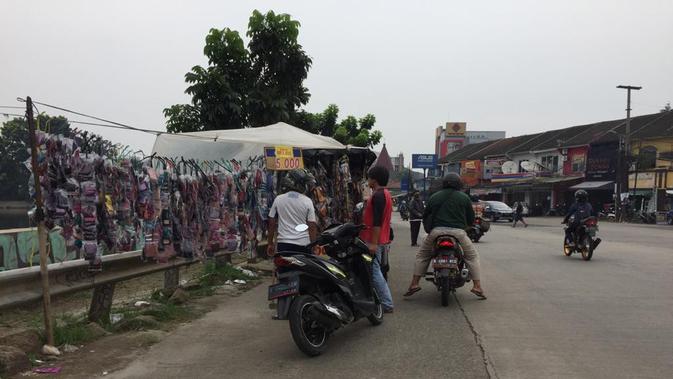 Pedagang masker tepi jalan masih beroperasi di hari pertama pemberlakuan Pembatasan Sosial Berskala Besar (PSBB) kota Tangerang Selatan, Sabtu (18/4/2020). (Marco Tampubolon/Liputan6.com)