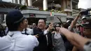 Seorang pengunjuk rasa pro-demokrasi (tegang) bersitegang dengan polisi dan massa anti-demokrasi di lokasi utama berlangsungnya aksi demonstasi di Admiralty, Hong Kong, (13/10/2014). (REUTERS/Carlos Barria)