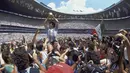 Penyerang Argentina, Diego Maradona, mengangkat trofi Piala Dunia saat usai mengalahkan Jerman Barat pada laga final Piala Dunia 1986 di Meksiko, (29/6/1986). (Photo by - / AFP)