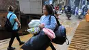 Sebagian warga menyelamatkan diri bersama barang bawaan. (JAIME SALDARRIAGA/AFP)