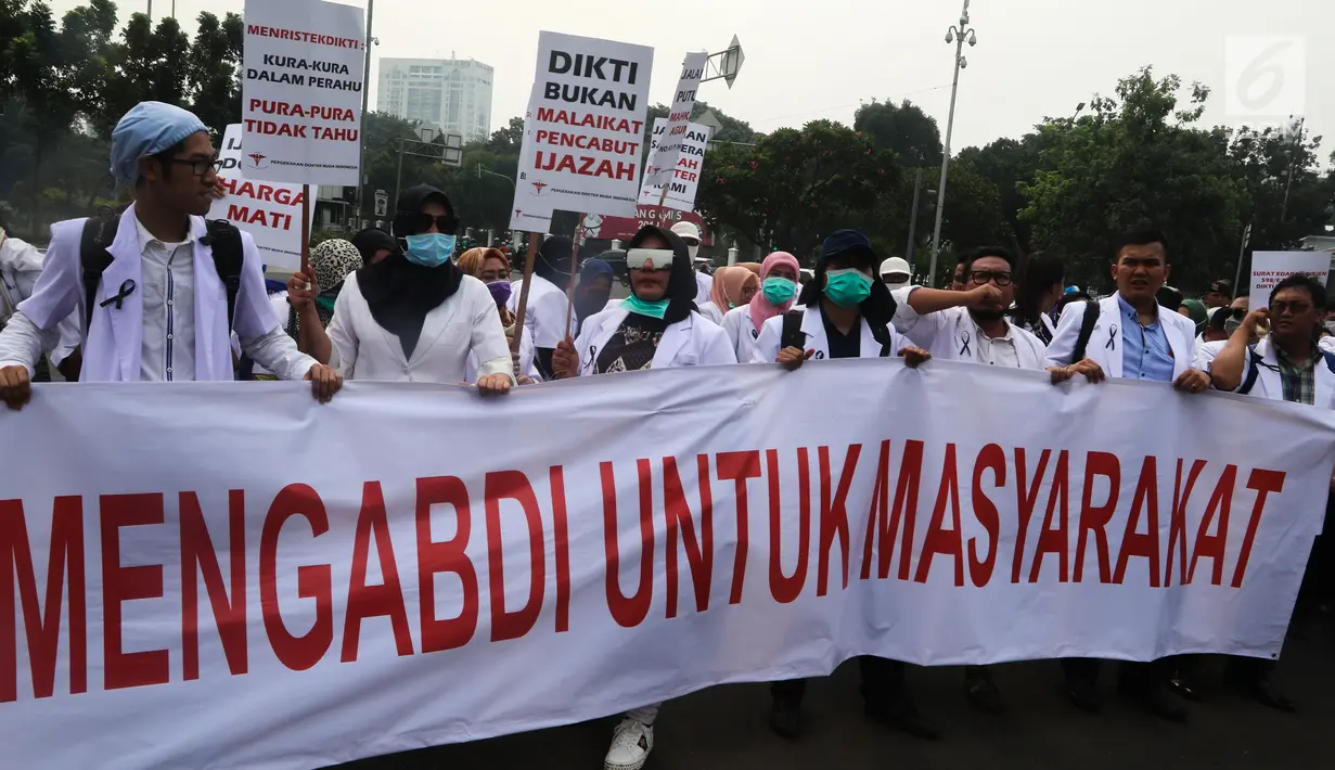 Sejumlah massa yang menamakan diri dari Pergerakan Dokter Muda Indonesia membentangkan spanduk saat melakukan aksi di depan Istana Negara, Jakarta, Kamis (19/7). (Liputan6.com/Johan Tallo)